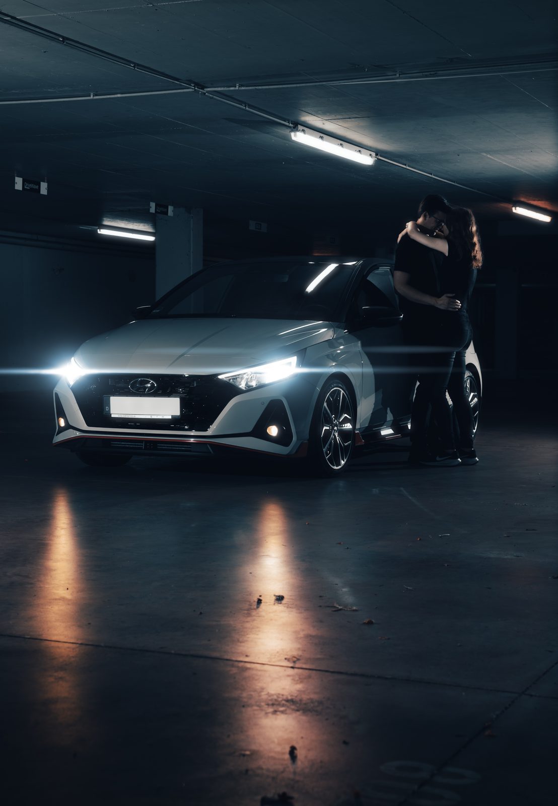 Editorial-Shooting mit Auto und Paar in der Tiefgarage